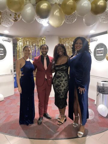 four people standing in front of a decorated doorway