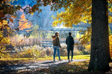 Visitors walk a path around a pond