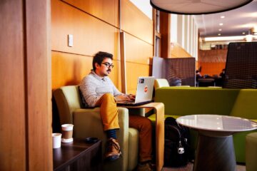 A student works on a laptop in Mann Library